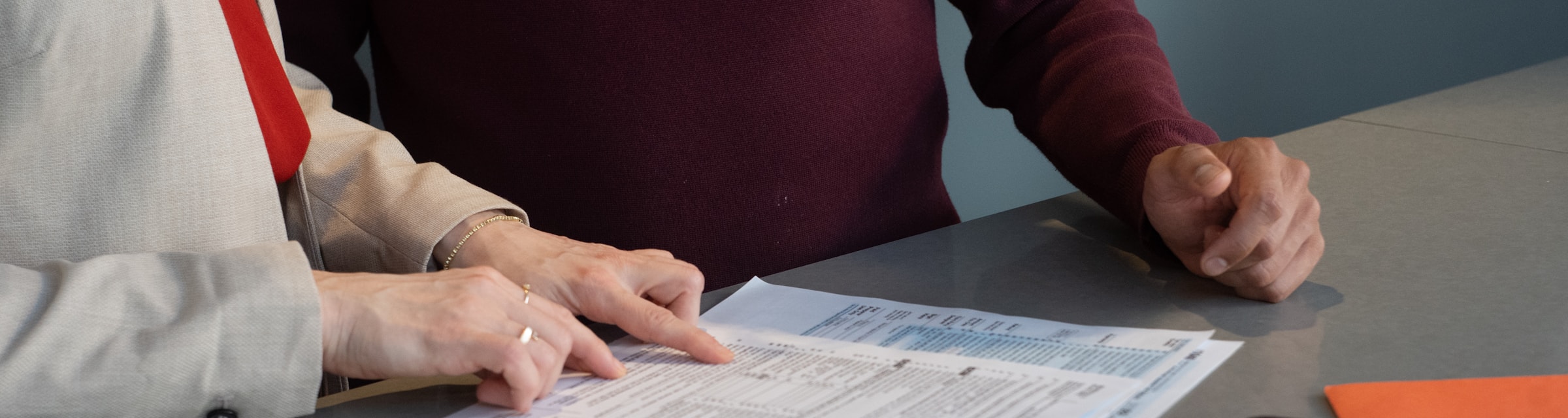 Photo of a compliance officer reviewing files — landscape